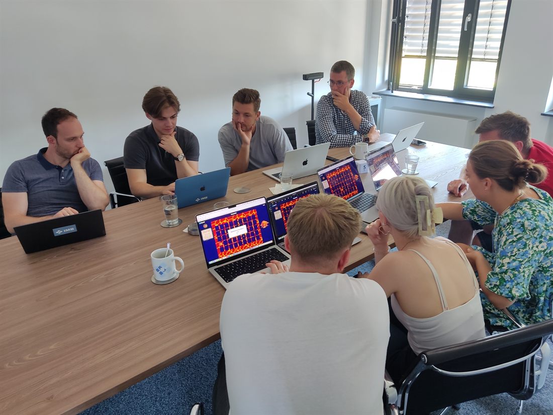 Gruppe sitzt an einem Tisch und wertet eine Aufgabe aus
